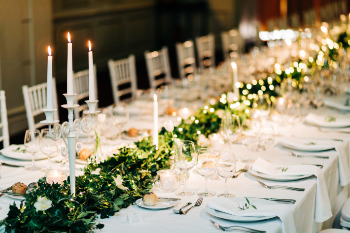 Świąteczny długi stół z białą zastawą i świeczkami
