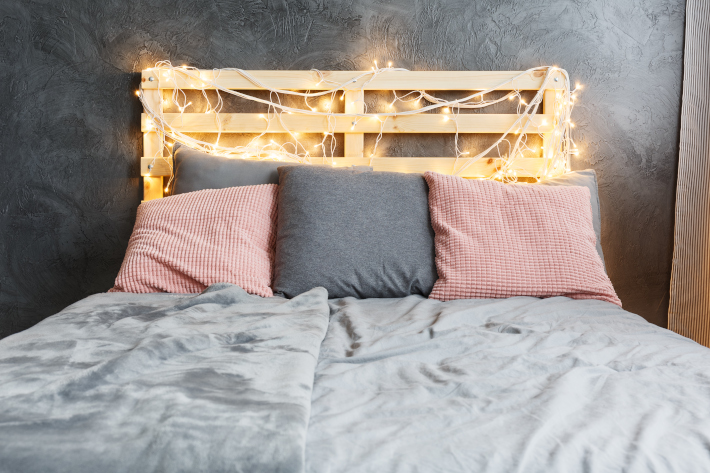 Lampki choinkowe użyte do dekoracji wezgłowia łóżka